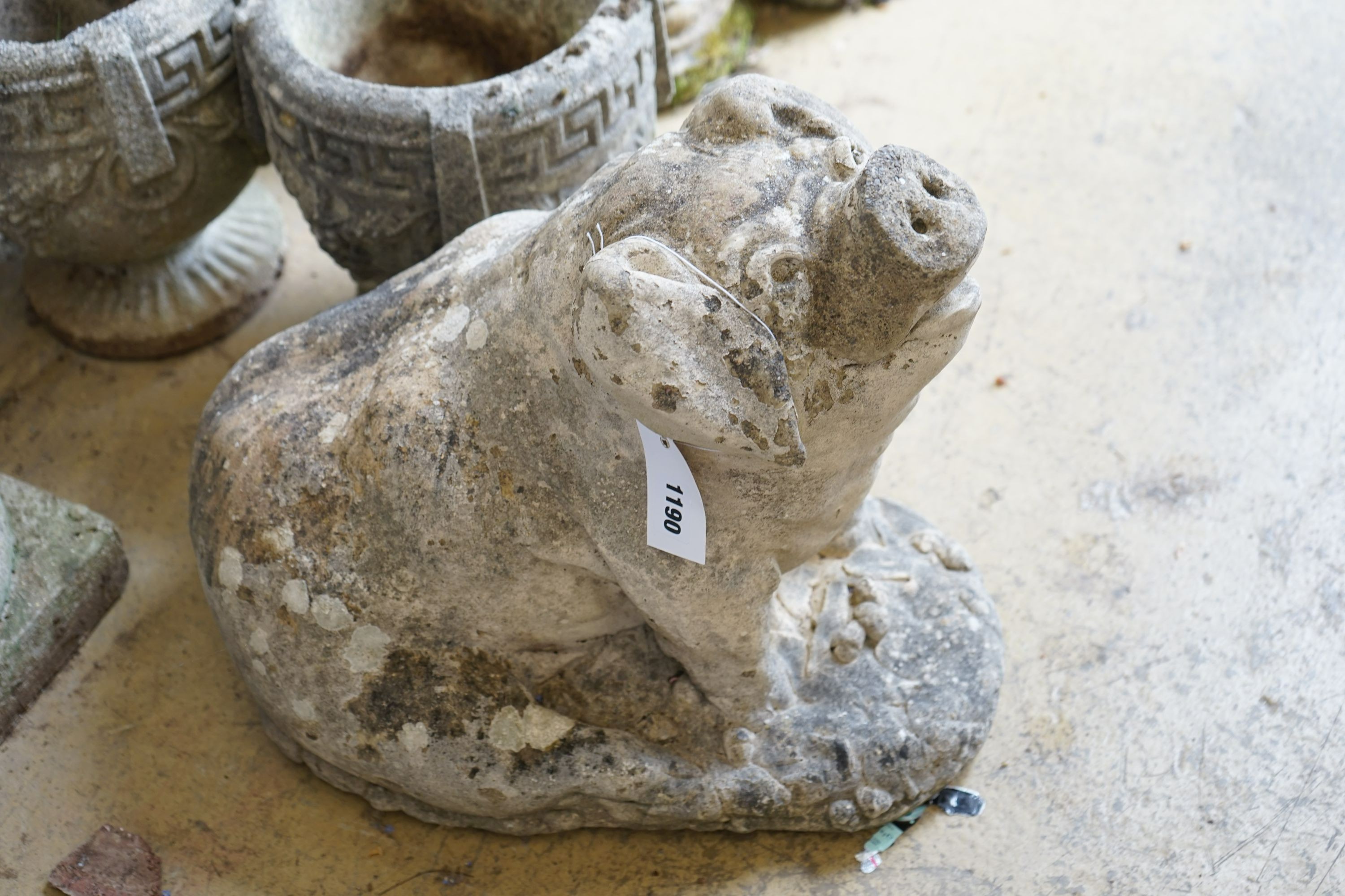 A reconstituted stone seated pig garden ornament, height 38cm